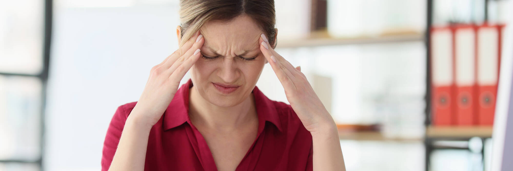 Migraine suffering woman holding her head