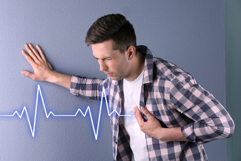 Man holding chest with palpitations